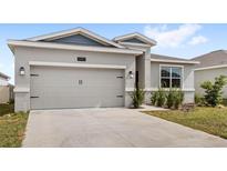 Beautiful home boasting a two-car garage and tidy landscaping at 1443 Lassen St, Haines City, FL 33844