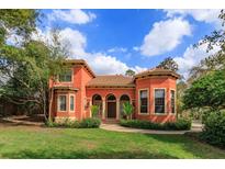 Charming two-story home with a beautiful lawn, arched entryway, and a clay tile roof at 2102 Sturbridge Ct, Winter Springs, FL 32708