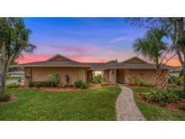 Charming single-story home featuring lush landscaping, stone accents, and a welcoming walkway at 221 W Berkshire Cir, Longwood, FL 32779