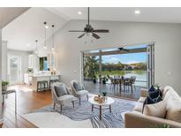 Spacious living room with a vaulted ceiling, hardwood floors and views of the lake at 3111 Carmia Dr, Orlando, FL 32806