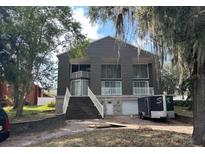 Modern two-story home with gray siding, dual balconies, and a spacious driveway at 8322 Lake Lucy Dr, Orlando, FL 32818