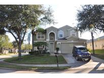 Charming two-story home featuring lush landscaping and an attached two-car garage in a suburban neighborhood at 913 Henley Cir, Davenport, FL 33896