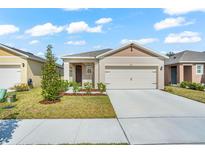 Charming one story home with a manicured lawn, a two-car garage and neutral color palette at 993 King Parc Rd, Orange City, FL 32763