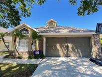 Charming single-story home with well-maintained lawn and two-car garage at 10313 Crystal Point Dr, Orlando, FL 32825