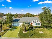 Charming single-story home with well-manicured lawn, bright red door, and a two-car garage at 11643 Sw 137Th Loop, Dunnellon, FL 34432