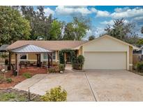 Charming single-story home with a two-car garage, complemented by a lovely pergola-covered seating area and manicured front yard at 22 Sweetwater Creek Cir, Oviedo, FL 32765