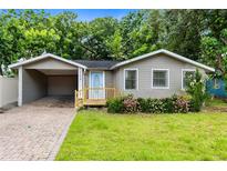 Charming single-story home featuring a carport and well-maintained front yard with fresh landscaping at 2208 Page Ave, Orlando, FL 32806