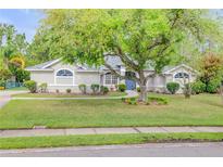 Inviting single-story home with lush green lawn, mature shade tree, and manicured landscaping at 27 Foxhunter Flt, Ormond Beach, FL 32174
