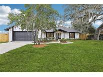 Charming home featuring a lush front yard and a two-car garage at 305 Haverlake Cir, Apopka, FL 32712