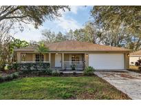 Charming single-story home with well-manicured lawn and inviting front porch at 820 Cypress Oak Cir, Deland, FL 32720