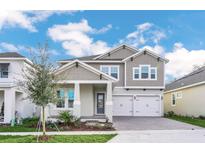 Charming two-story home featuring a two-car garage, landscaped front yard, and modern architectural details at 13062 Sunrise Harvest Dr, Winter Garden, FL 34787