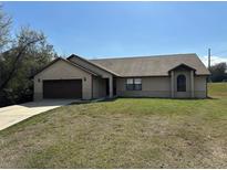 Charming single-story brick home featuring an attached two-car garage and well-maintained front lawn at 1811 Springwood Ln, Deltona, FL 32725