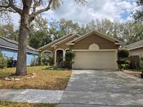 Charming single-story home featuring a neutral exterior, well-maintained landscaping, and an attached two-car garage at 2119 Kaylas Ct, Orlando, FL 32817