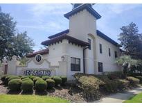 View of the 'Registry at Michigan Park' building with a beautiful sign and lush landscaping at 5550 E Michigan St # 1210, Orlando, FL 32822