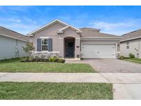 Charming single-story home with a well-maintained lawn, stone accents, and a two-car garage at 704 Hyperion Dr, Debary, FL 32713