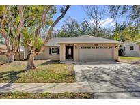 Charming single-story home featuring a two-car garage and well-maintained lawn at 7448 Grand Ct, Winter Park, FL 32792