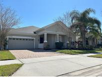 Charming single-story home with a brick driveway, two-car garage, and well-maintained landscaping at 8744 Currituck Sound Ln, Orlando, FL 32829