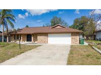 Charming single-story brick home featuring an attached two-car garage and a well-maintained front yard at 986 Sweetbrier Dr, Deltona, FL 32725