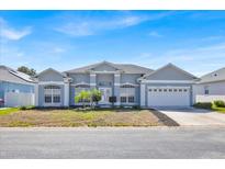 Charming single-story home featuring a well-manicured lawn and attached two-car garage at 1409 Golf Course Pkwy, Davenport, FL 33837