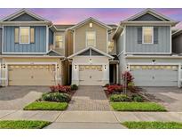 Charming townhome with a brick paver walkway, attached garage, and well-manicured landscaping at 2258 Sedge Grass Way, Orlando, FL 32824