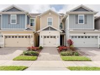 Charming townhome with attached garage, beautiful landscaping, and brick paver walkway at 2258 Sedge Grass Way, Orlando, FL 32824