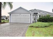 Charming single-story home featuring a two-car garage and a well-manicured front yard at 2628 Caribe Dr, The Villages, FL 32162