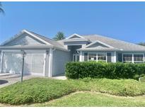Charming single-story home with well-manicured landscaping and a two-car garage at 2628 Caribe Dr, The Villages, FL 32162
