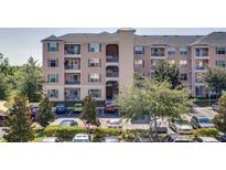 Exterior view of a condo building featuring multiple floors, balconies, and well-maintained landscaping and full parking lot at 3177 Feltrim Pl # 304, Kissimmee, FL 34747