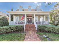 Inviting two-story home featuring a charming front porch, brick walkway, and manicured landscaping at 4268 Ethan Ln, Orlando, FL 32814