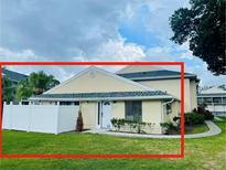 Inviting home featuring a well-maintained lawn, white picket fence, and lush landscaping at 4439 Pinebark Ave # 47-4, Orlando, FL 32811