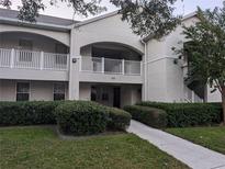 Condo building exterior showcasing well-maintained landscaping, walkways, and second-story balconies with white railings at 570 Cranes Way # 246, Altamonte Springs, FL 32701