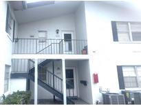 Two-story condo featuring multiple units with private entrances and iron stair railing at 6042 Amberly Ave # F55, Orlando, FL 32822