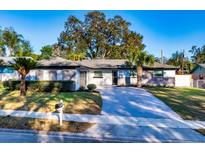 Charming single story home with well-maintained lawn, mature trees, and a long driveway at 605 Hill Ave, Ocoee, FL 34761