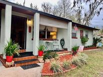 Charming single-story home featuring a covered porch, lovely landscaping, and an inviting entrance at 701 S Delaware Ave, Deland, FL 32720