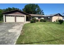 Charming single-story home with a well-maintained lawn and an attached two-car garage at 12314 Virginia Dr, Leesburg, FL 34788