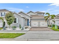 Charming two-story home with a two-car garage, blue door, and a well-manicured yard at 16259 Misty Hills Ave, Winter Garden, FL 34787