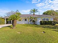 Charming single-story home featuring a well-manicured lawn and welcoming front entrance with rocking chairs at 2405 Janet St, Kissimmee, FL 34741