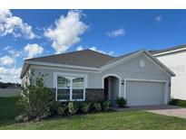 Single story home with gray exterior, gray stone accent and two car garage at 4317 Deleon St, Haines City, FL 33844