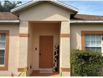 Inviting front door and covered entry with welcome mat and tasteful landscaping at 504 Delido Way, Kissimmee, FL 34758