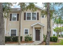 Charming two-story townhome with neutral siding, brown shutters and door, and well-maintained landscaping at 5356 Diplomat Ct # 105, Kissimmee, FL 34746