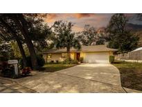 Charming single-story home with a well-manicured front yard, palm tree, and a two-car garage at 690 Shady Ct, Altamonte Springs, FL 32701