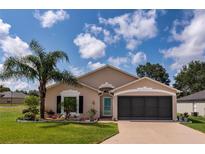 Charming single-story home featuring a well-manicured lawn, beautiful landscaping, and an attached two-car garage at 730 Garberia Dr, Davenport, FL 33837