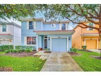 Charming two-story home with a well-manicured lawn and a driveway leading to a one-car garage at 8900 Candy Palm Rd, Kissimmee, FL 34747