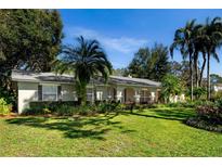 Charming single story home featuring a large, well-manicured front yard, mature trees, and arched entryway at 11 Stone Gate S, Longwood, FL 32779