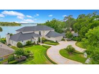 Stately two-story home featuring a circular driveway and lush, manicured landscaping and lake view at 2504 Gatlin Ave, Orlando, FL 32806