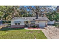 Charming single-story home with a well-manicured lawn, brick accents, and an attached one car garage at 2833 Ne 18Th Ct, Ocala, FL 34470