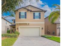 Two-story home with a two-car garage, brick-paved driveway and manicured lawn at 339 Capron Ash Loop, Casselberry, FL 32707