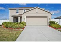 Charming two-story home with a two-car garage, landscaped yard, and a welcoming front porch at 365 Quarry Rock Cir, Kissimmee, FL 34758