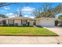 Charming single-story home featuring a well-manicured lawn and stone accents at 4754 E Wind St, Orlando, FL 32812