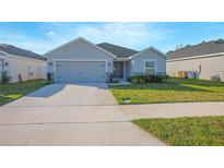 Charming single-story home with a well-maintained lawn and gray exterior paint at 5430 Pine Lilly Dr, St Cloud, FL 34771